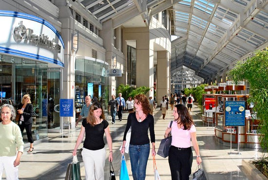 Customers with bags in hand walk the aisles of The Shops at Prudential Center in Boston, Massachusetts.