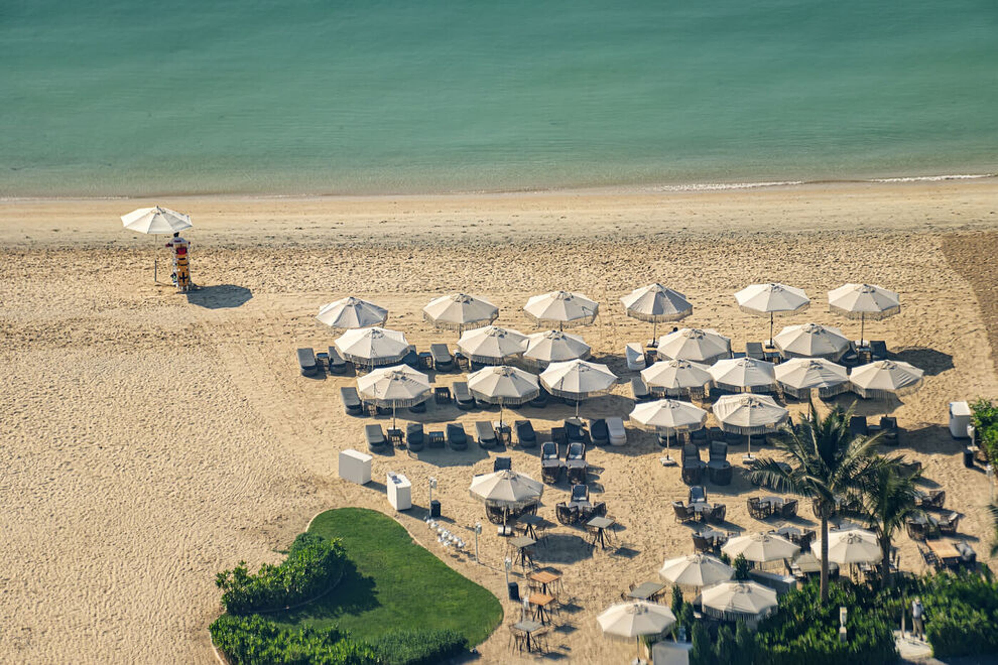 Beach with tourists enjoying the sun and sea, sitting under umbrellas aerial top view from above timelapse. Beach with tourists enjoying the sun and sea, sitting under umbrellas aerial top view from above timelapse.