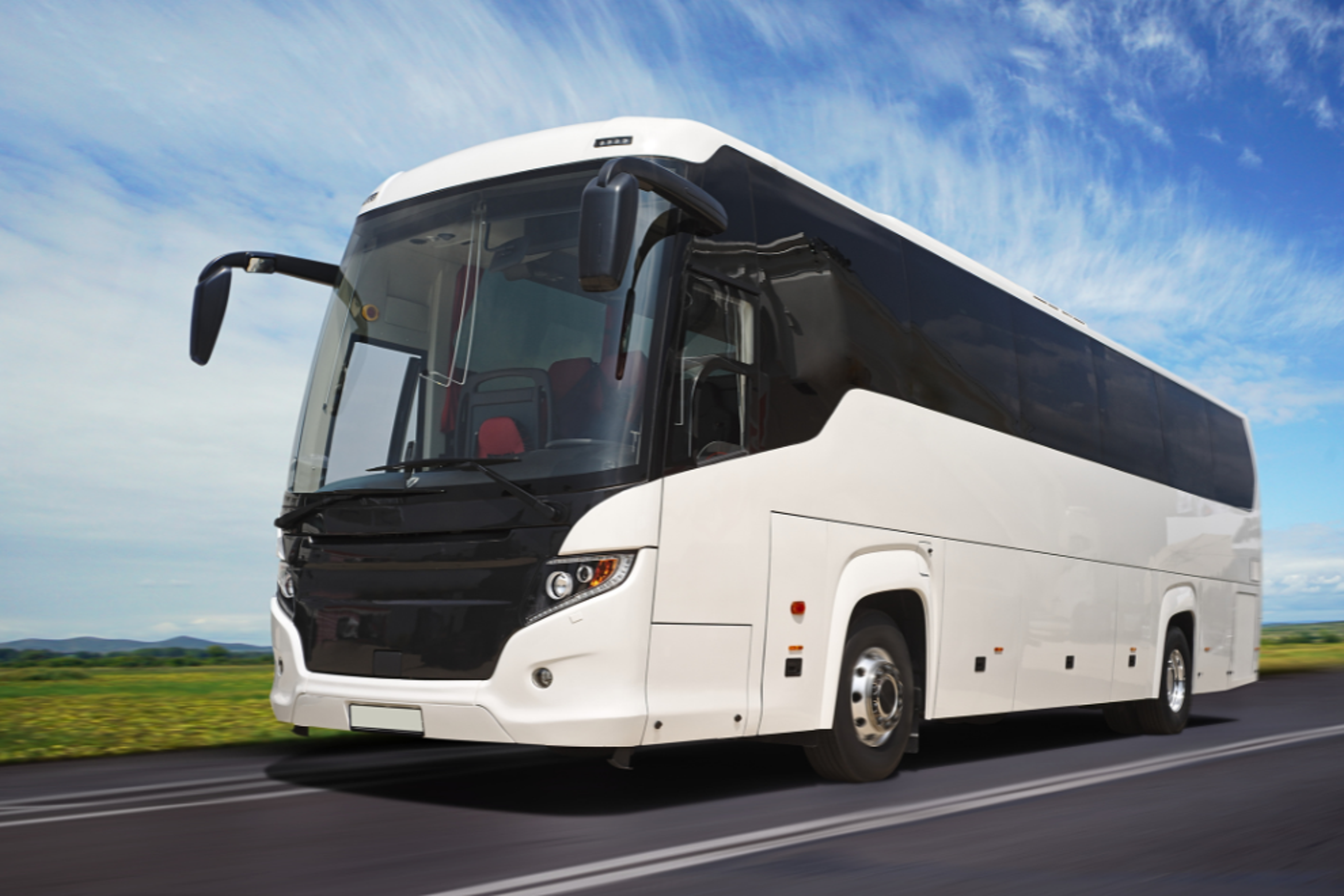 White coach bus on a highway.